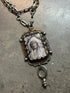 Vintage-style necklace with a pendant on a gray surface