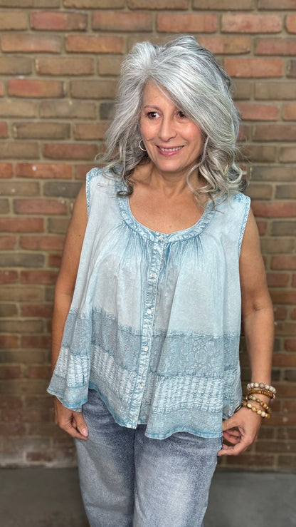 Woman wearing the Denim Blue Crochet Contrast Tank Top, a light blue sleeveless top and jeans standing against a brick wall.