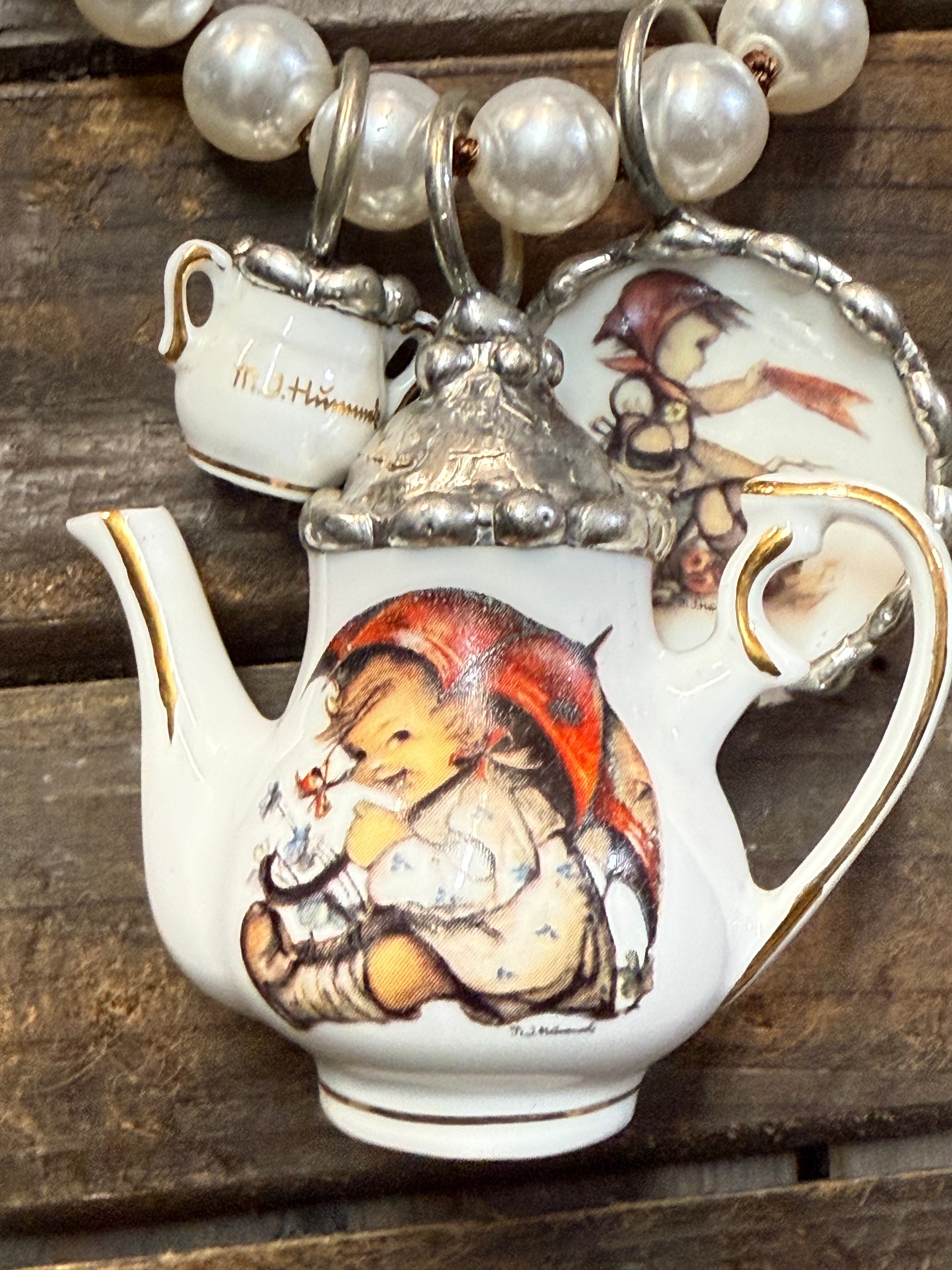 Decorative teapot with child illustrations on a wooden surface