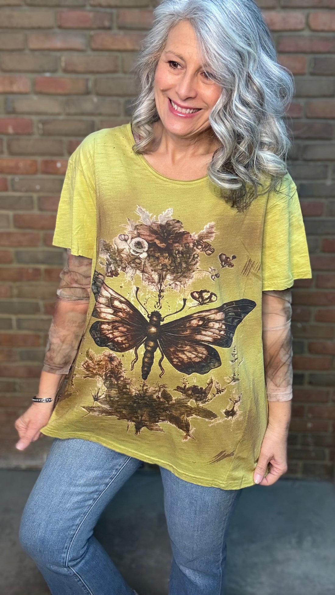 Woman wearing Moon Dance Tee - Evening Stop in front of a brick wall.