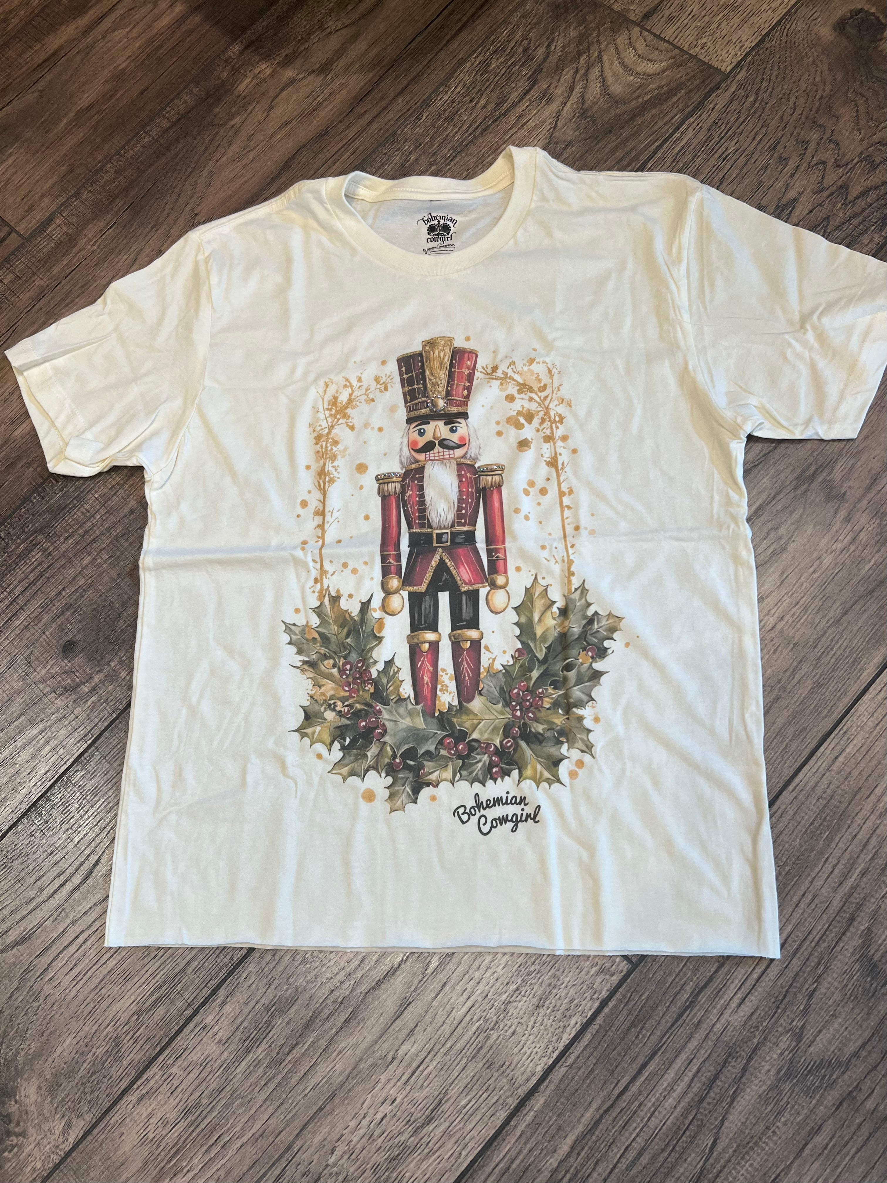 White t-shirt with a nutcracker design on a wooden floor