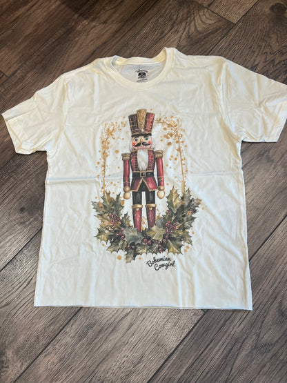White t-shirt with a nutcracker design on a wooden floor