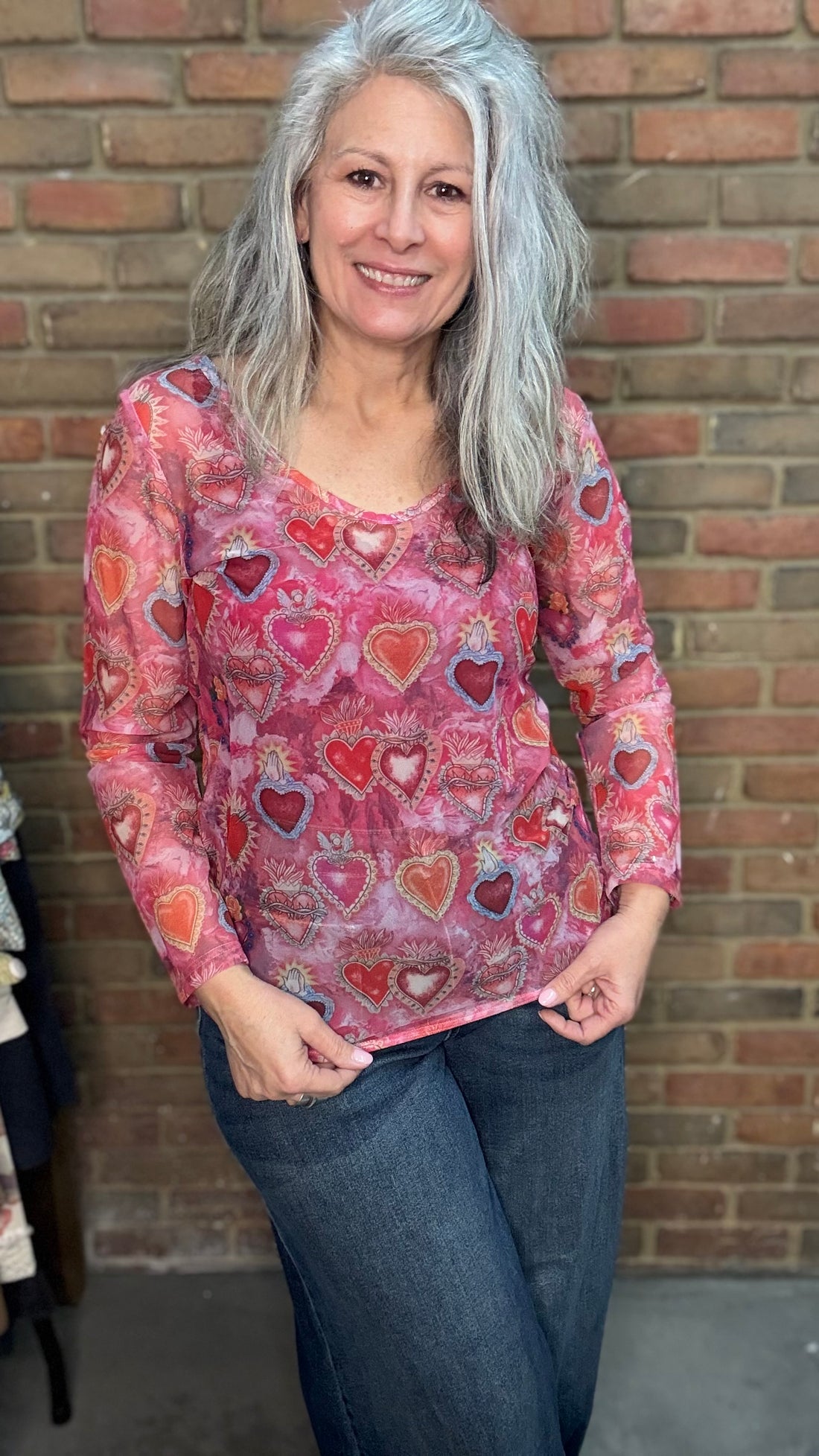 woman wearing the Heart Mesh Top in a S/M against a brick wall