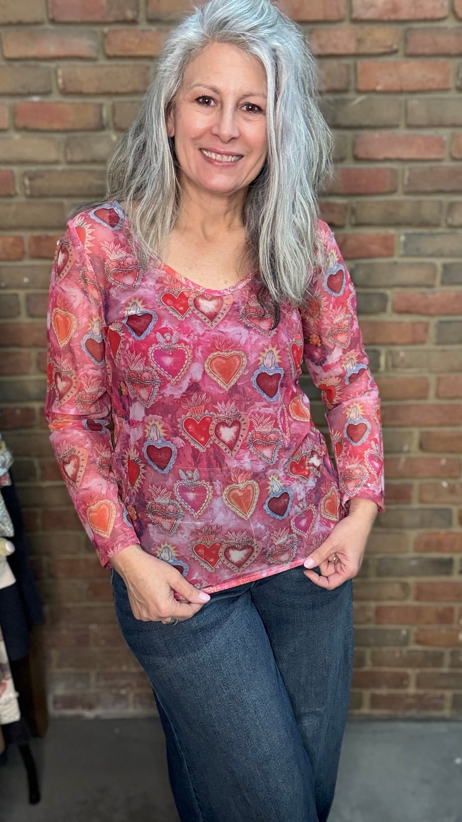 woman wearing the Heart Mesh Top in a S/M against a brick wall