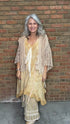Woman wearing the crochet Forever Timeless Split Tails Jacket over the Wandering Spirit Dress with striped pants standing against a brick wall.