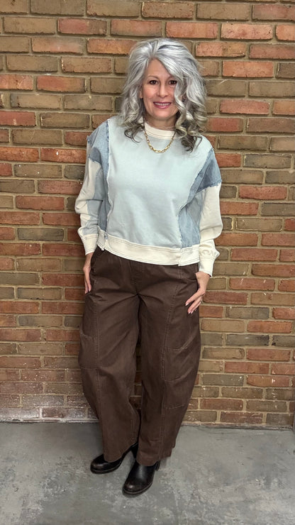 Person wearing the blue Color Block Pull on with the Brown Pull On Barrel Pants, standing against a brick wall.