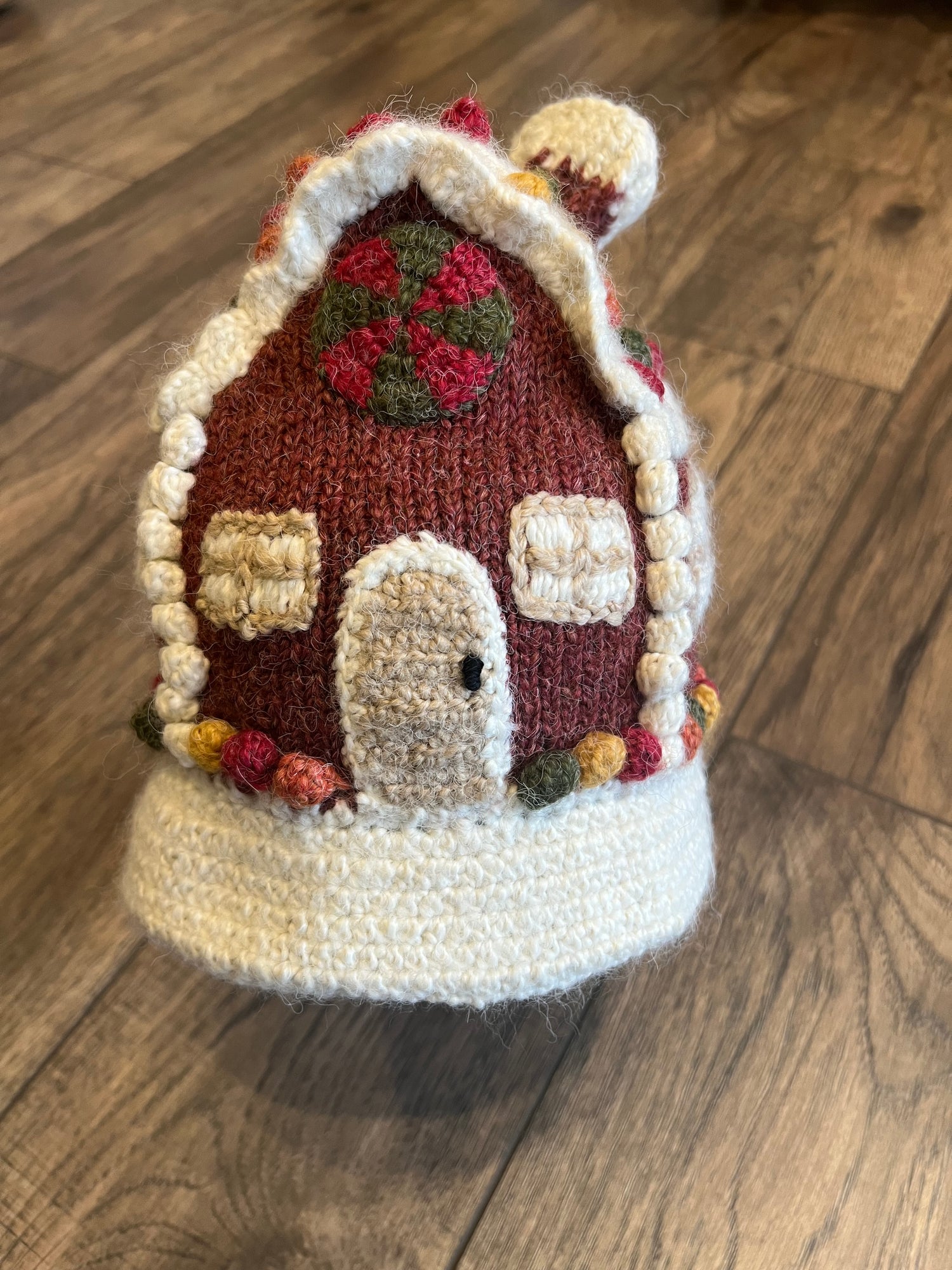 Knitted Gingerbread house on a wooden surface