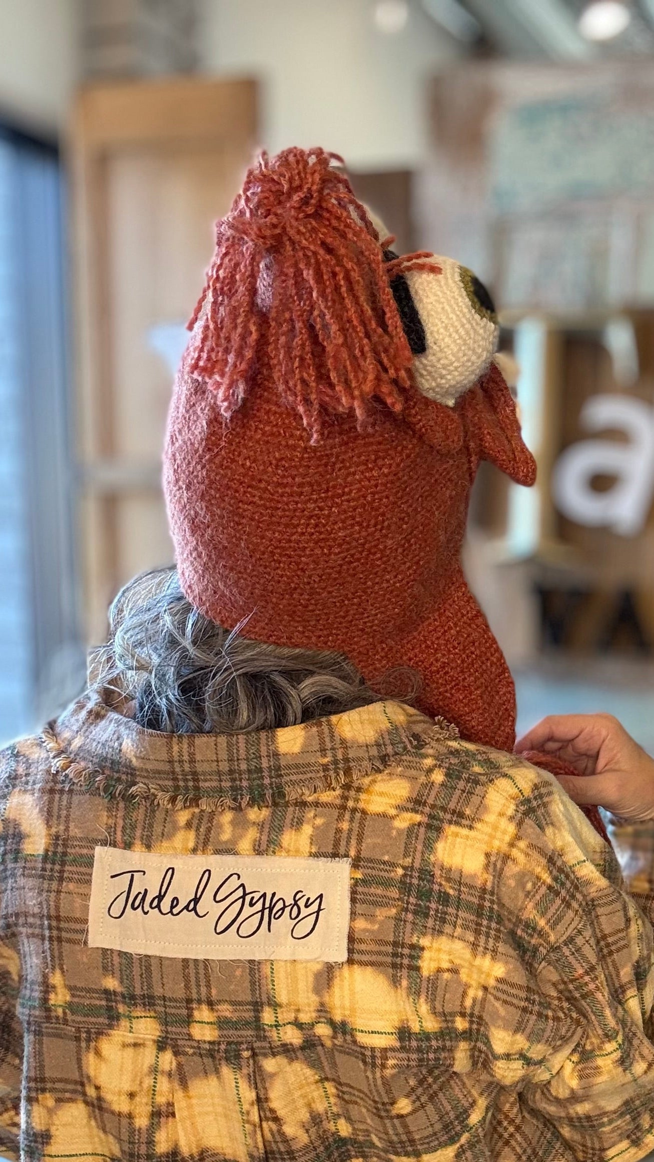 Person wearing a plaid shirt with &