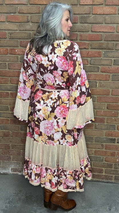 Woman wearing a floral dress with a brick wall background