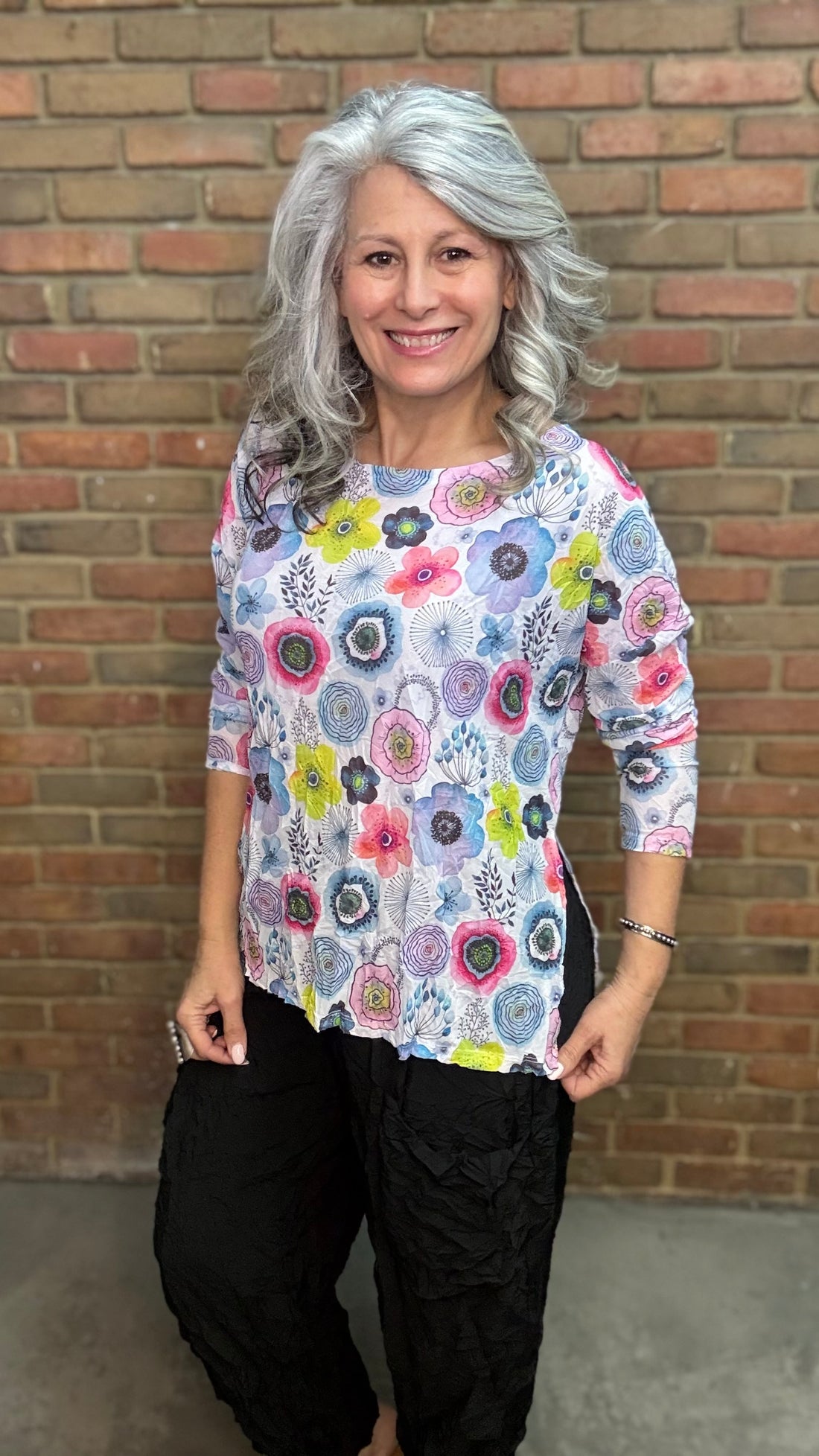 Woman wearing Floral Mesh Topper standing in front of a brick wall.