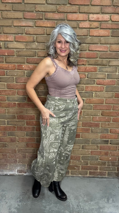 Woman wearing Lace Camisole and the Paisley Print Jean standing against a brick wall.
