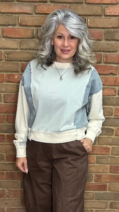 Person wearing the Color Block Pullover Top and the brown pullon barrel pants standing against a brick wall.