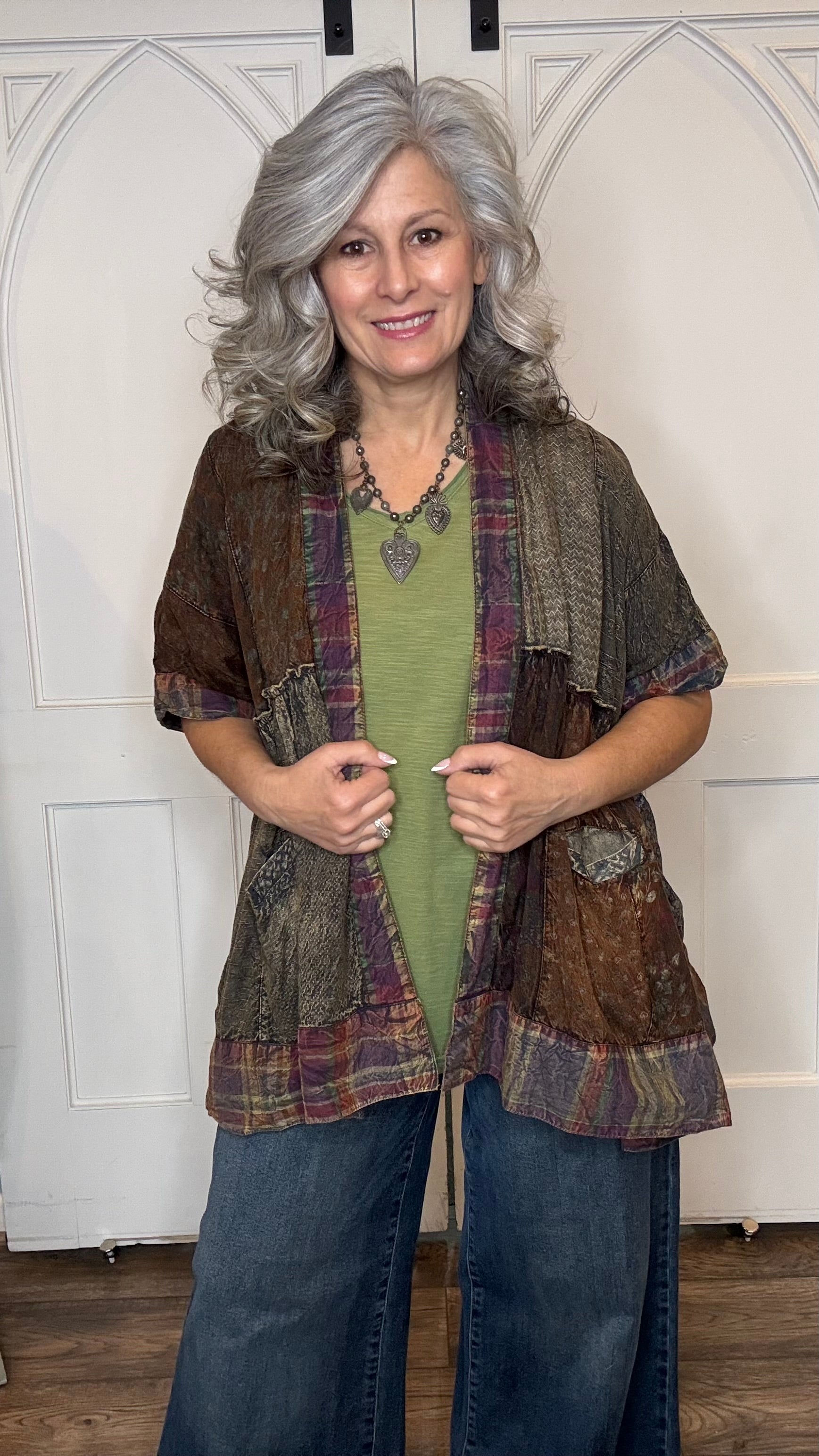 Woman wearing Boho Kimono Shrug Cardigan over a Moon Dance V-Neck in Olive and Judy Blue Palazzo Patch Pocket jeans in front of a white door.