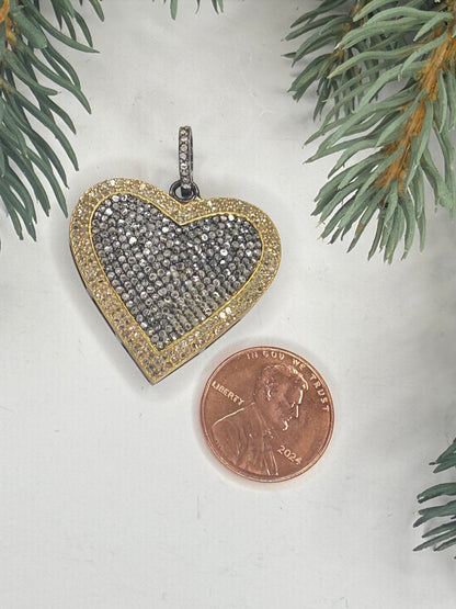 Heart-shaped pendant next to a penny on a light background with greenery.