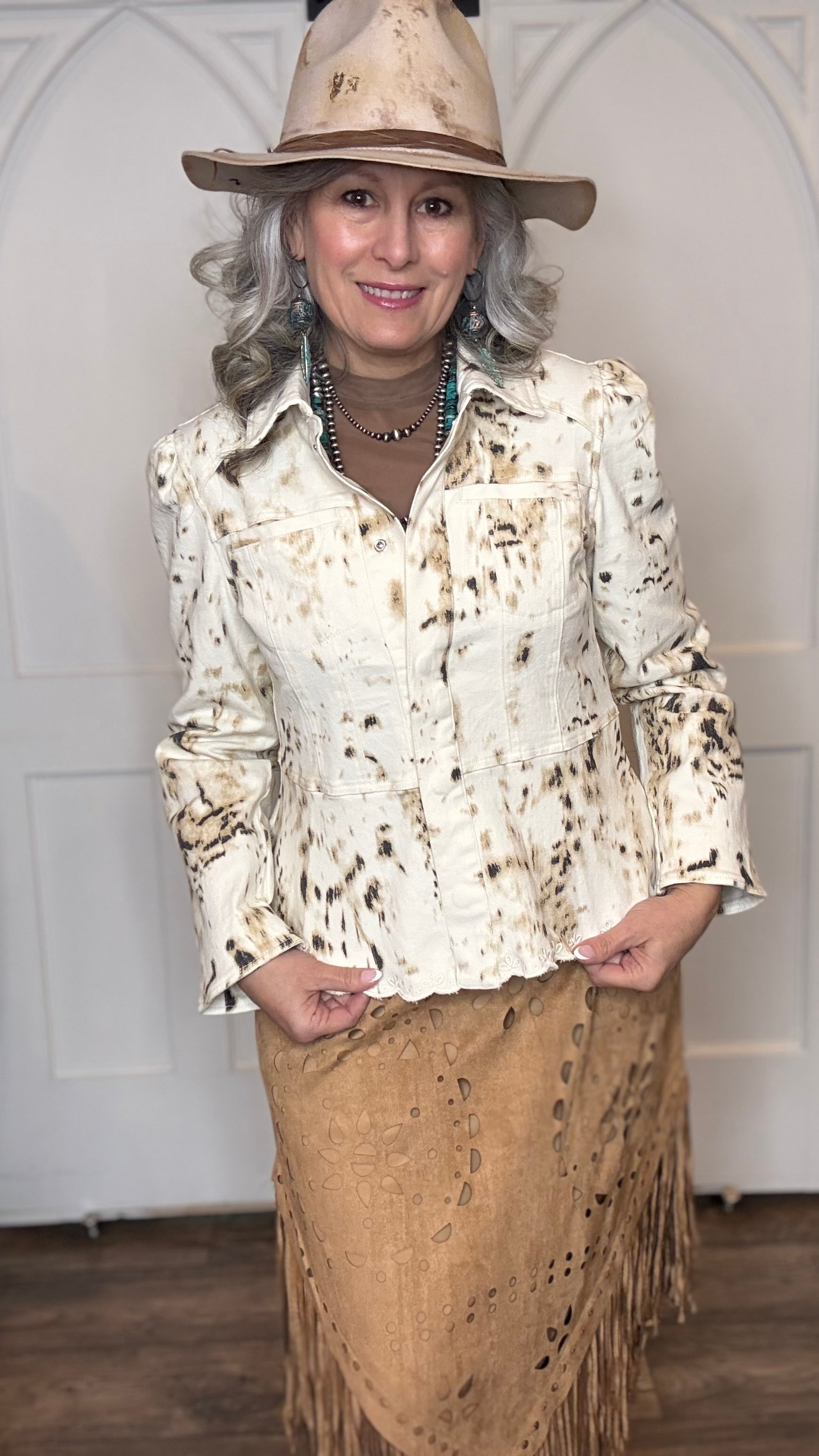 Woman wearing the Cow Print Scallop Edge Jacket with the Camel Faux Suede Fringe Skirt with the Pop&