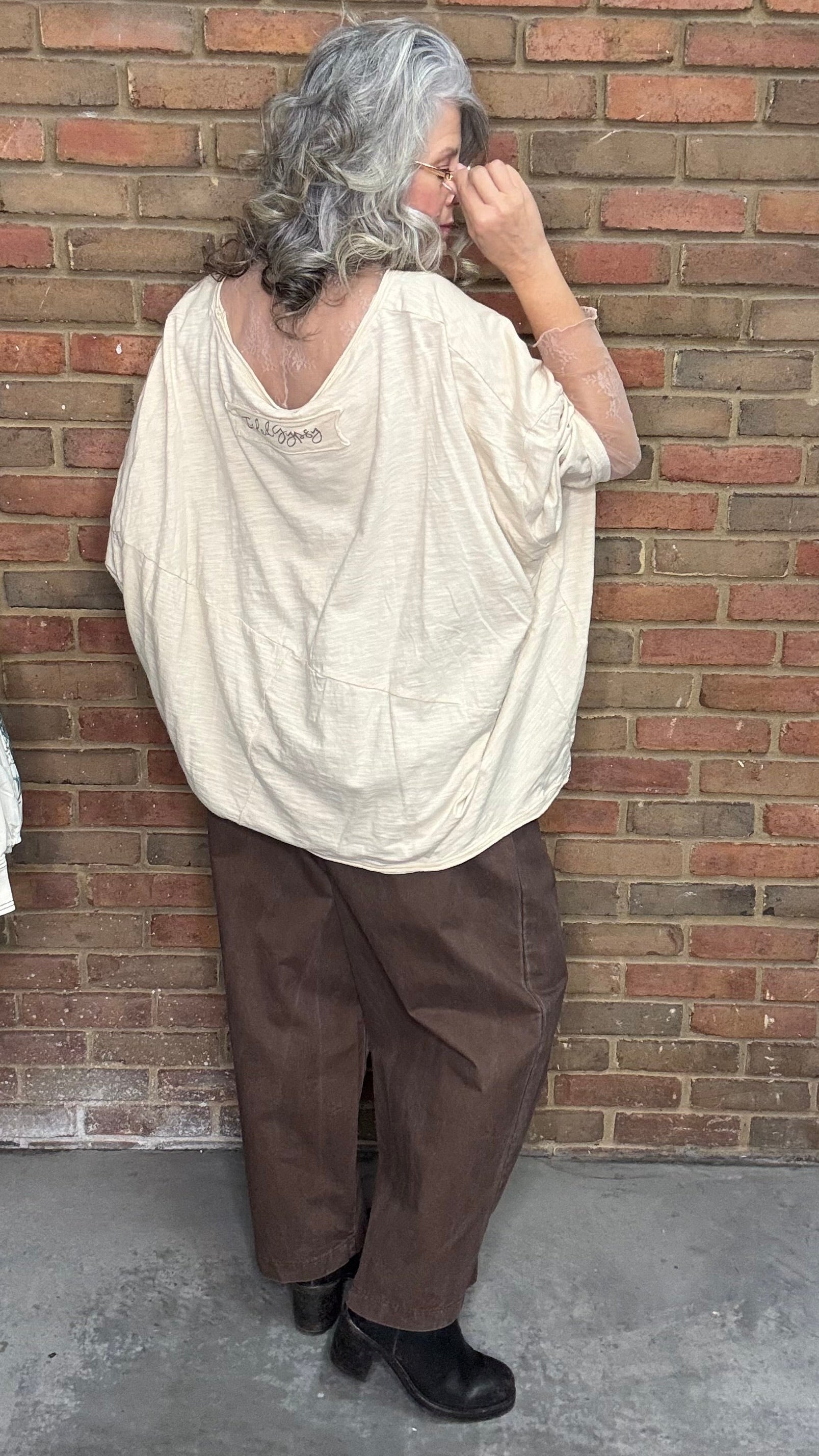 Person wearing the Be Free Growth Top and the Brown Pull On Pants against a brick wall.