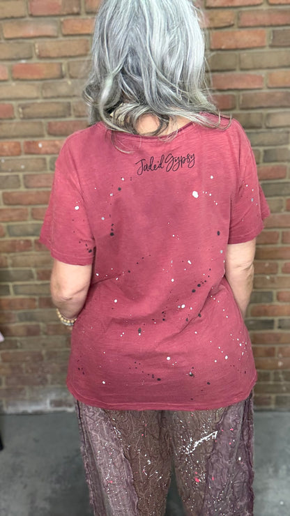 Woman in red shirt in front of brick wall.