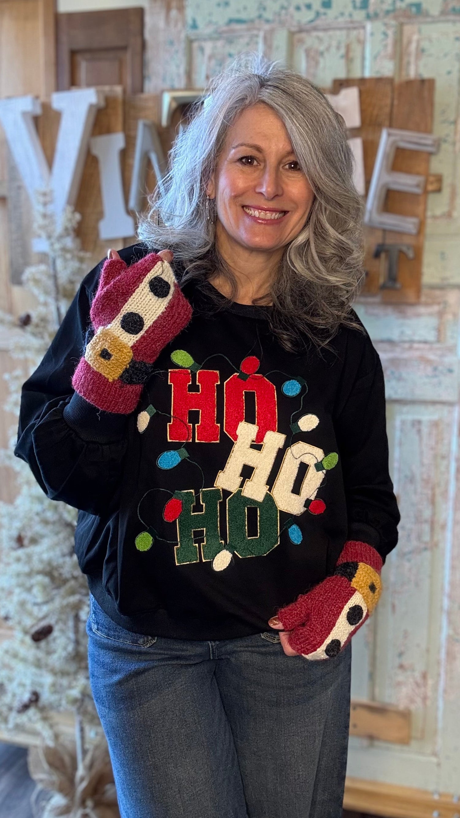 Woman wearing a black sweater with colorful &