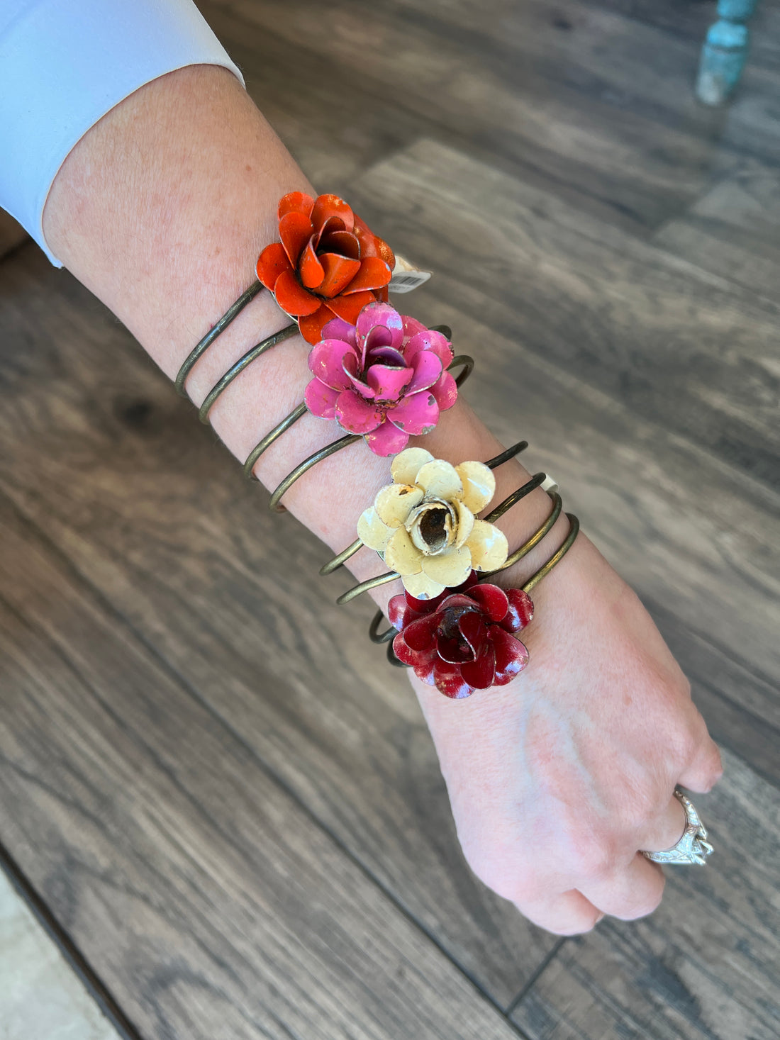 Flower Cuff on someones wrist with wood background.