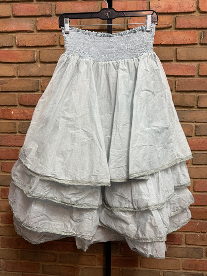 White dress on a hanger against a brick wall