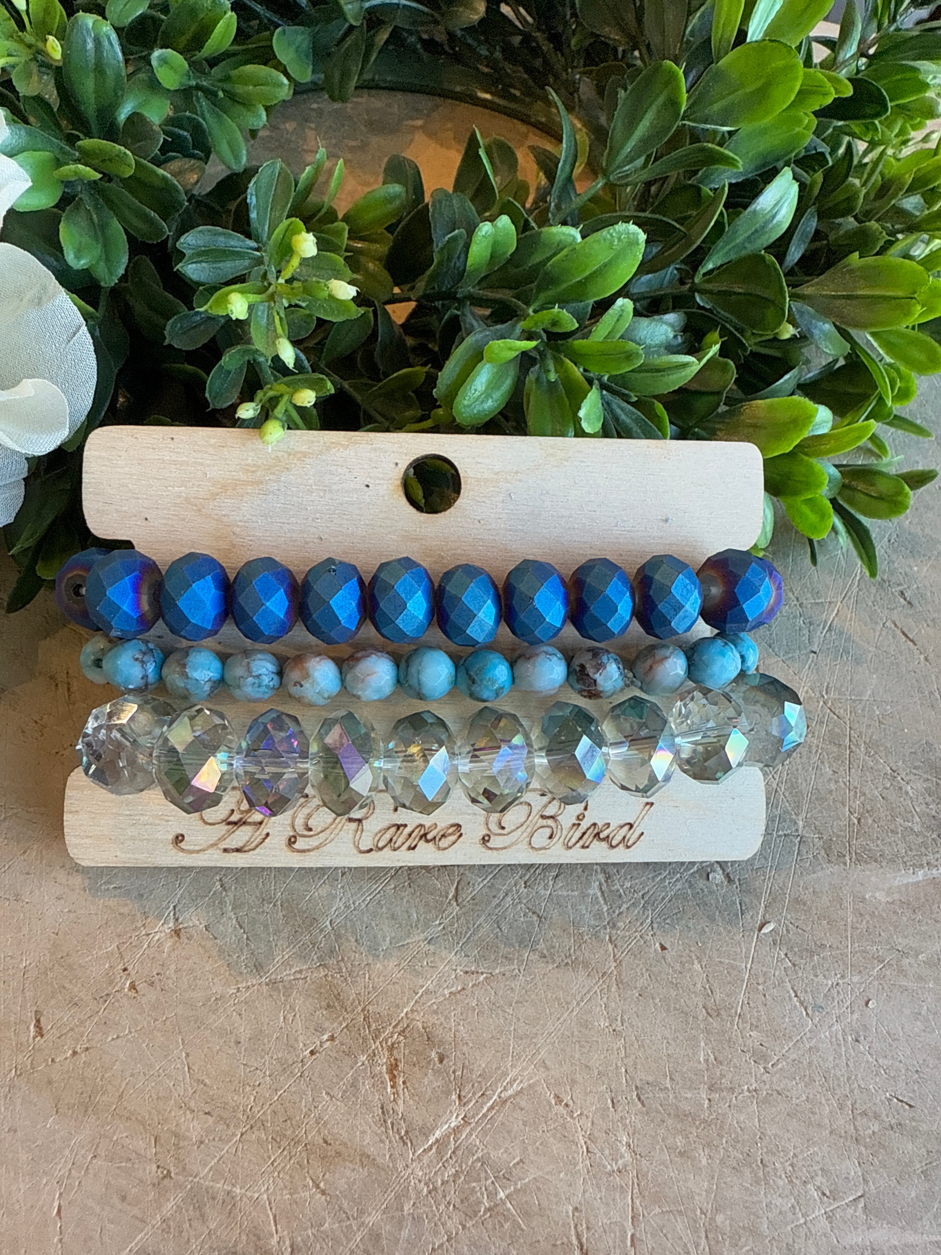 Crystal and Teal Stack Bracelets with greenery in the background