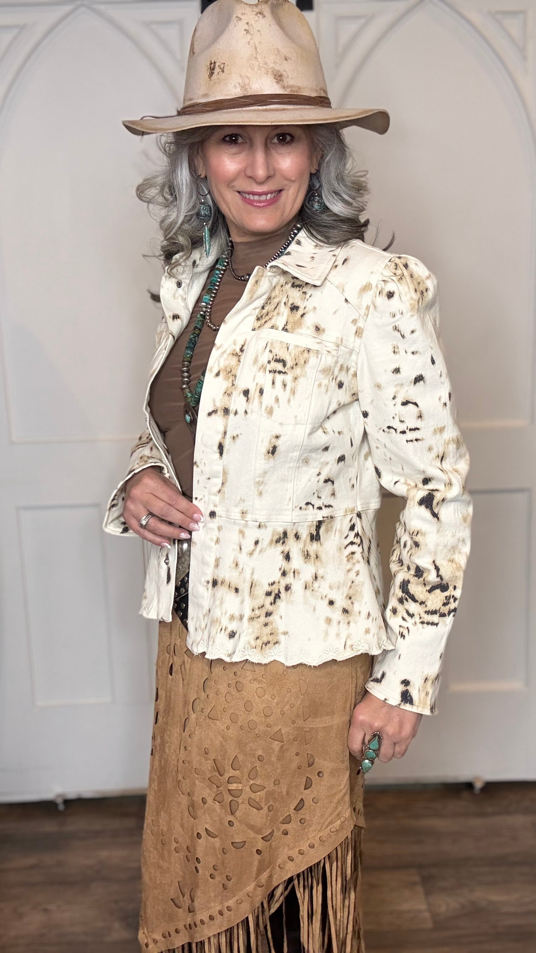 Woman wearing the Cow Print Scallop Edge Jacket with the Camel Faux Suede Fringe Skirt with the Pop&