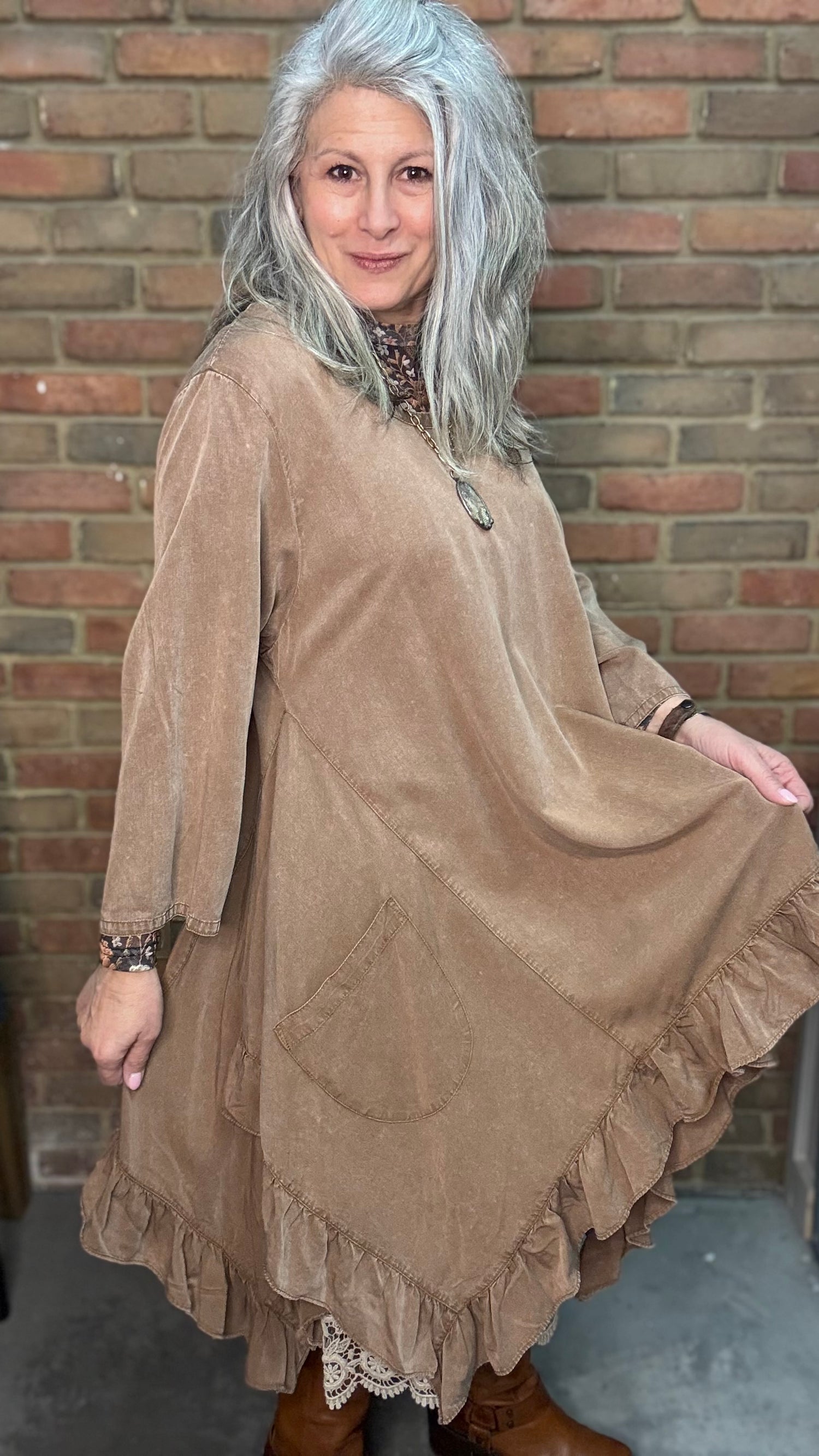 Woman wearing Tan Round Neck Ruffle Top/dress with a mesh top, slip, and Frye Boots.