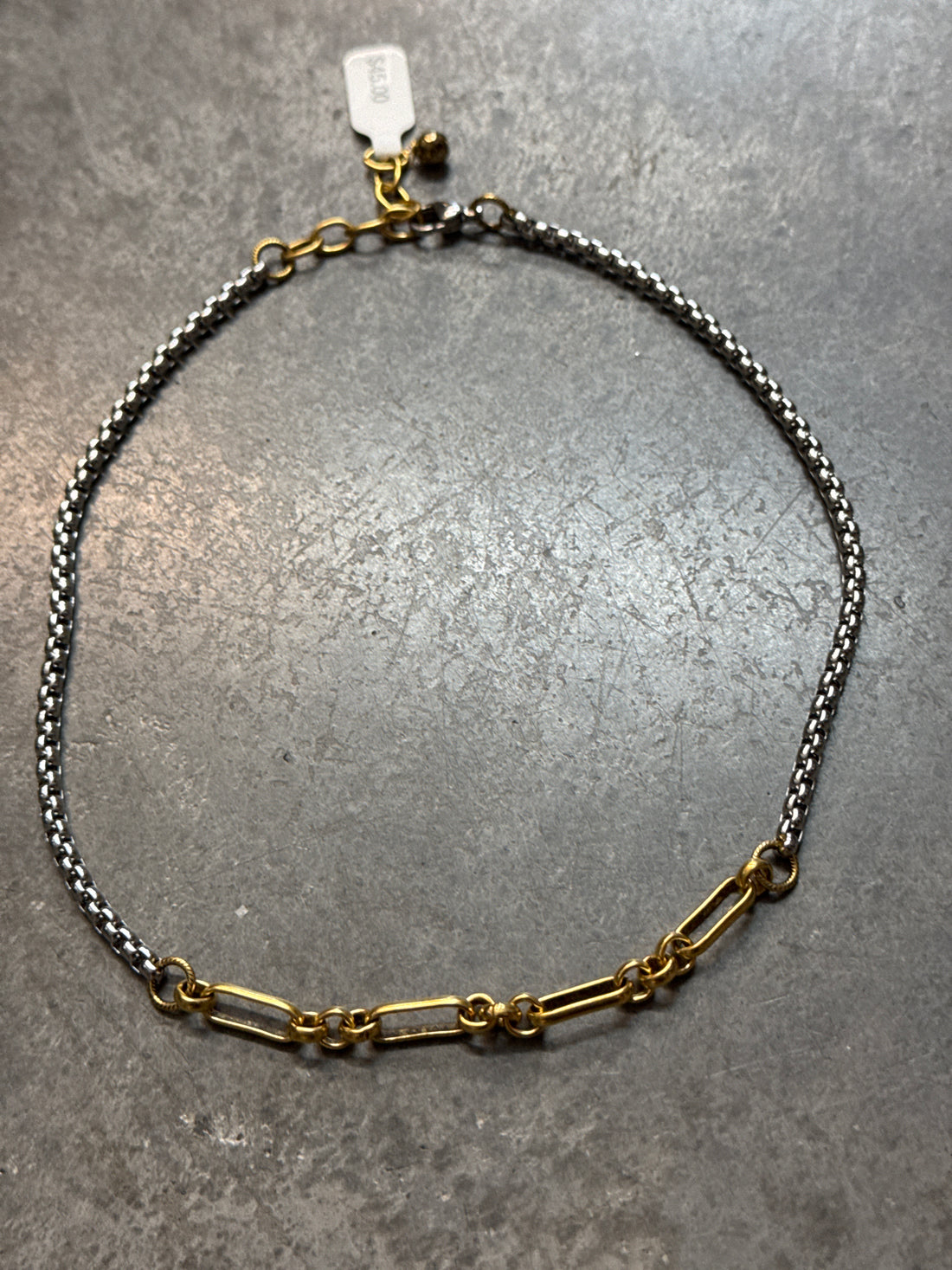 Two chain necklaces on a gray surface