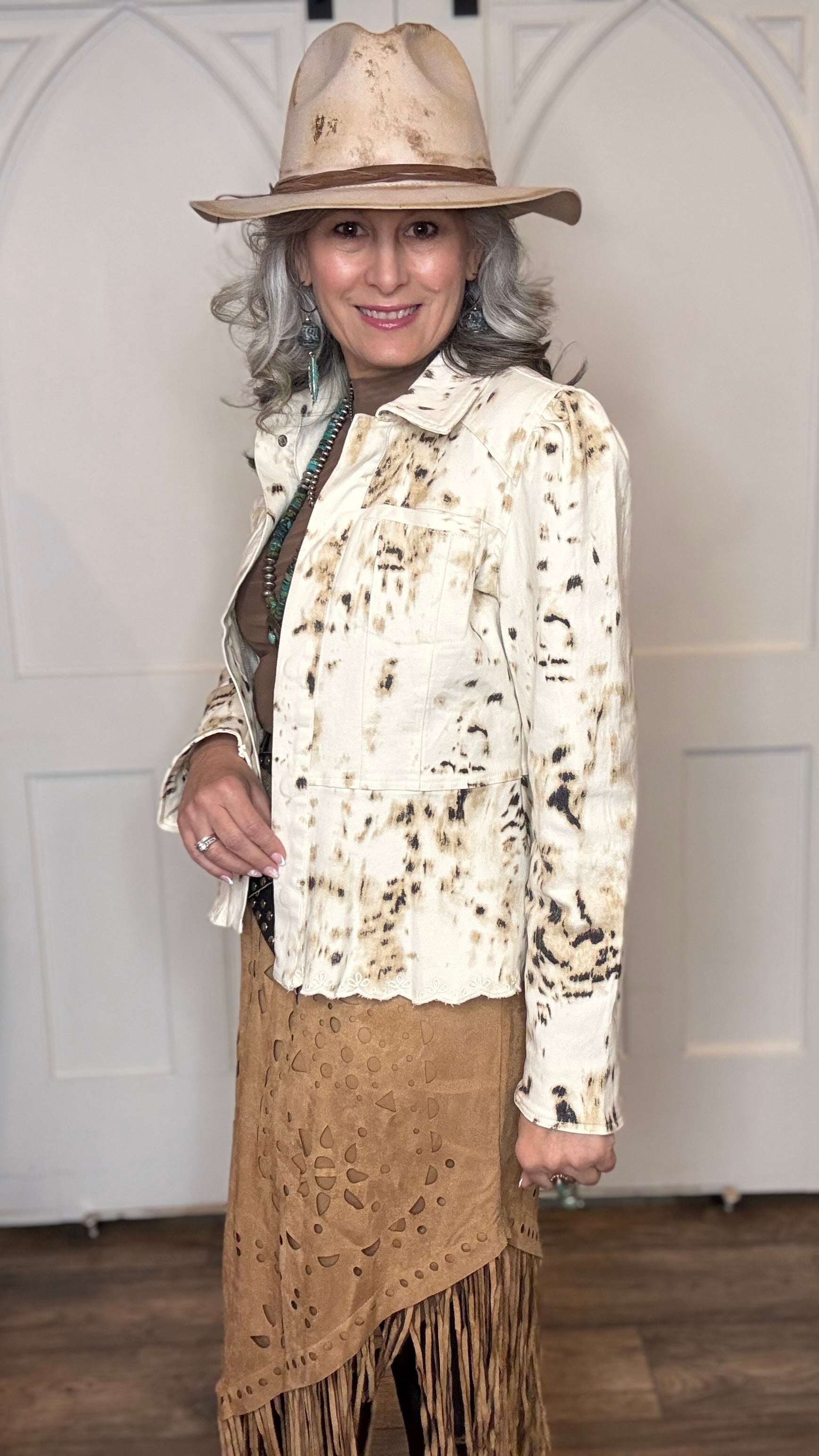 Woman wearing the Cow Print Scallop Edge Jacket with the Camel Faux Suede Fringe Skirt with the Pop&