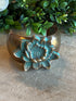 Brass Lotus Cuff on a textured surface with greenery