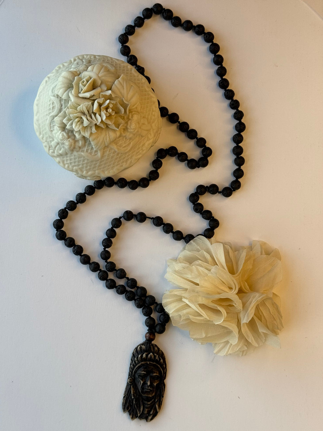 Black beaded necklace with Native American pendant on a white surface