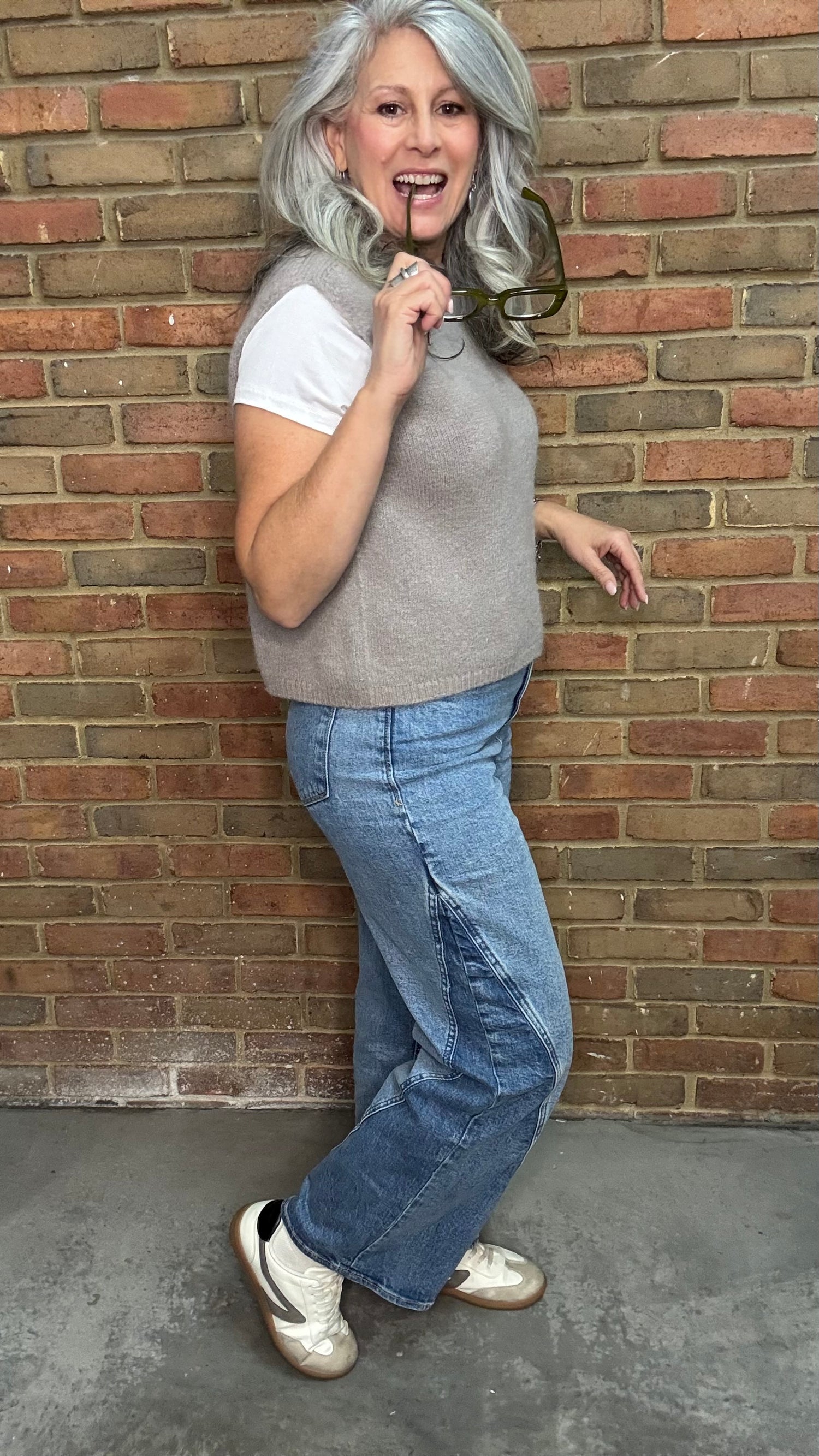 Woman in the HOLLY Super High Rise Two Tone Straight Jean casual outfit standing against a brick wall