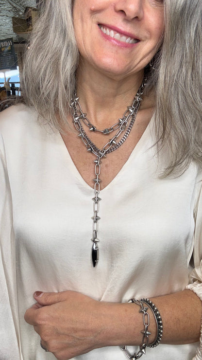 Woman wearing a silver necklace and bracelet with a blurred background