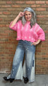 Woman wearing Bleached Wide Leg Jeans and Dusty Pink Ombre Sweater standing against a brick wall.