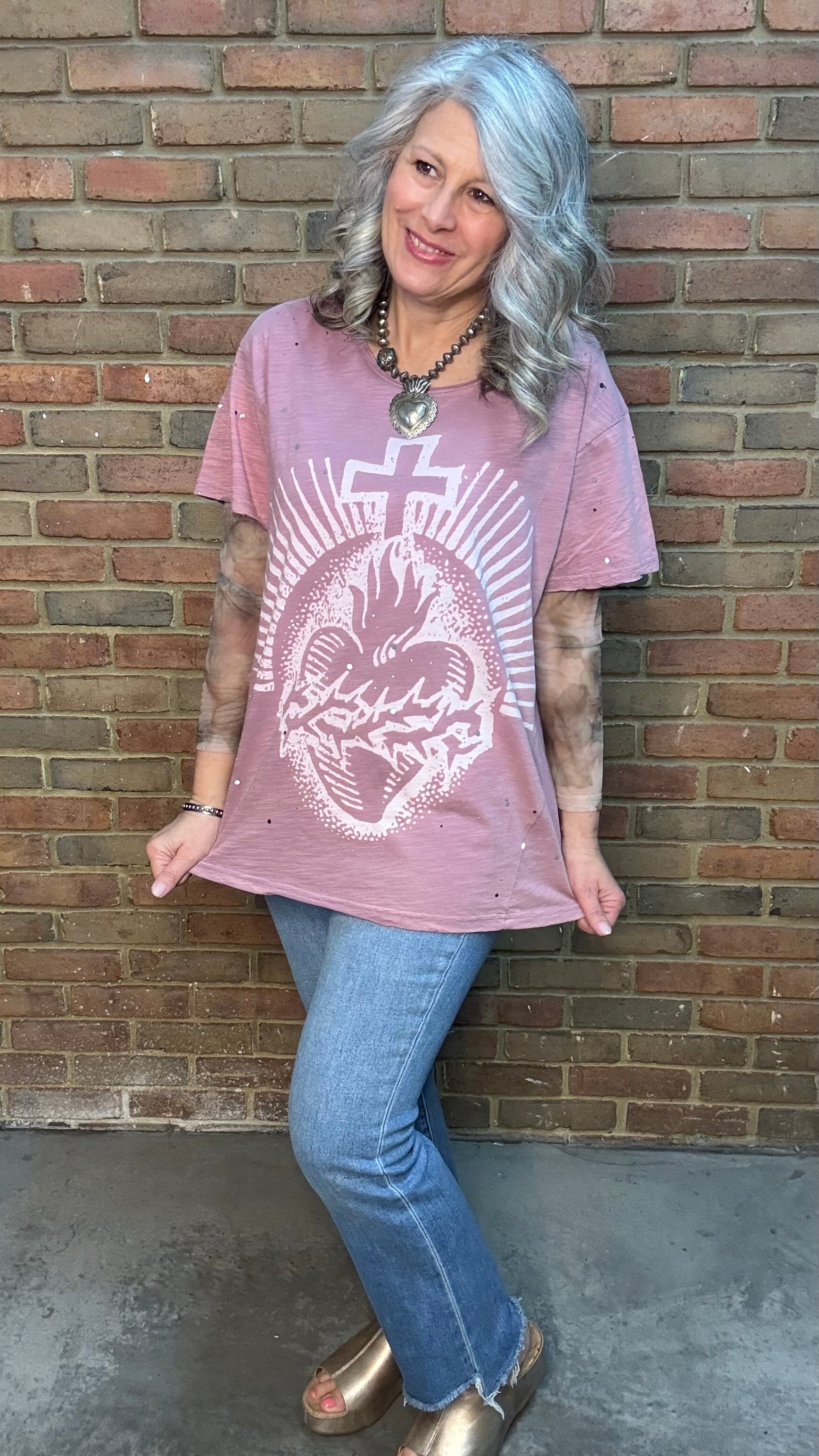 Woman wearing Moon Dance Tee - Cherished Heart tee against brick wall.