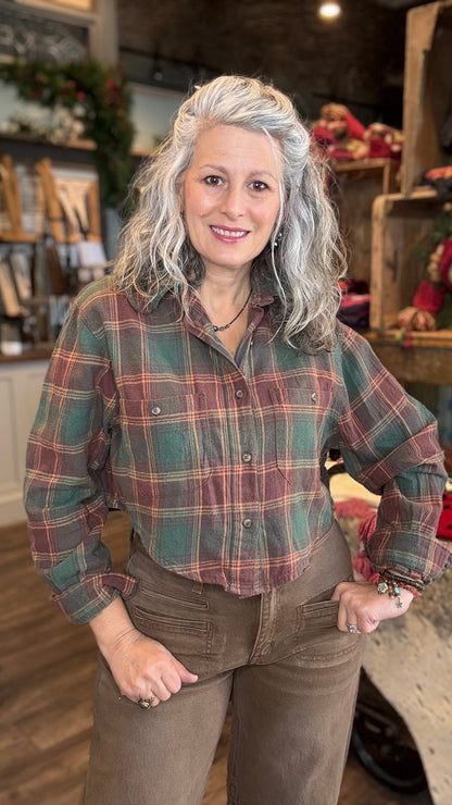 Woman wearing a green plaid crop shirt and brown pants in a store setting