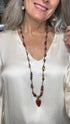 Woman wearing a beaded necklace with a close-up of the necklace on a white background