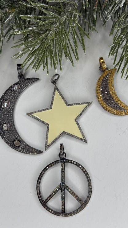 Jewelry pendants including a star, crescent moon, and peace symbol on a snowy background.