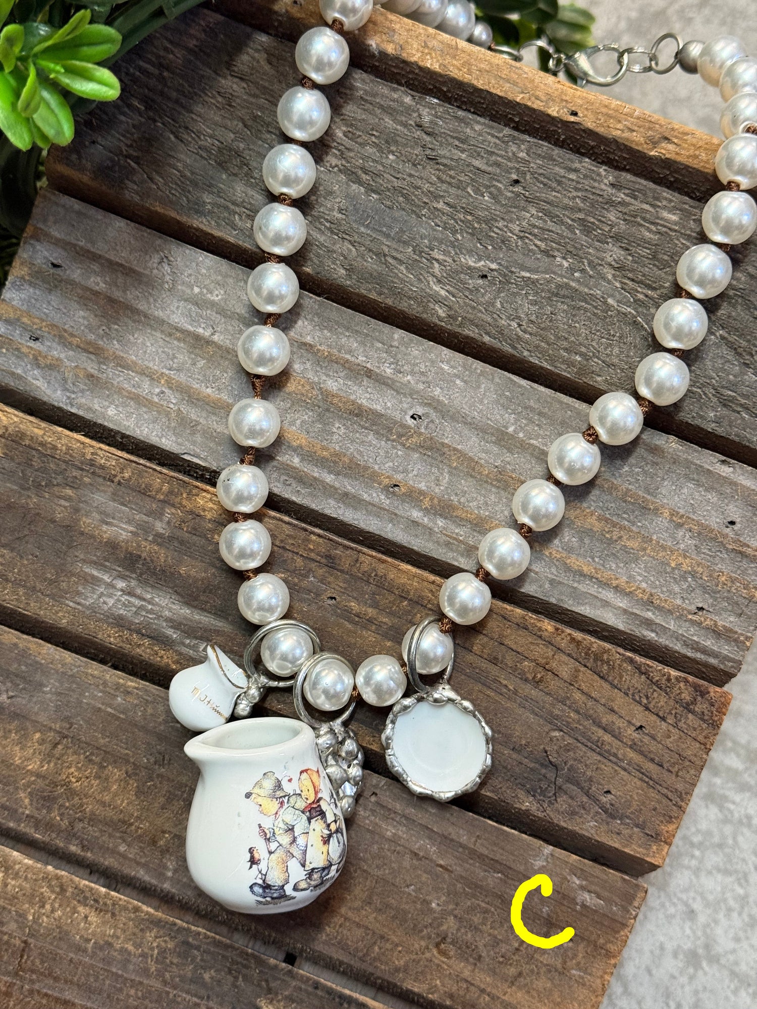 Pearl necklace with a decorative pendant on a wooden surface