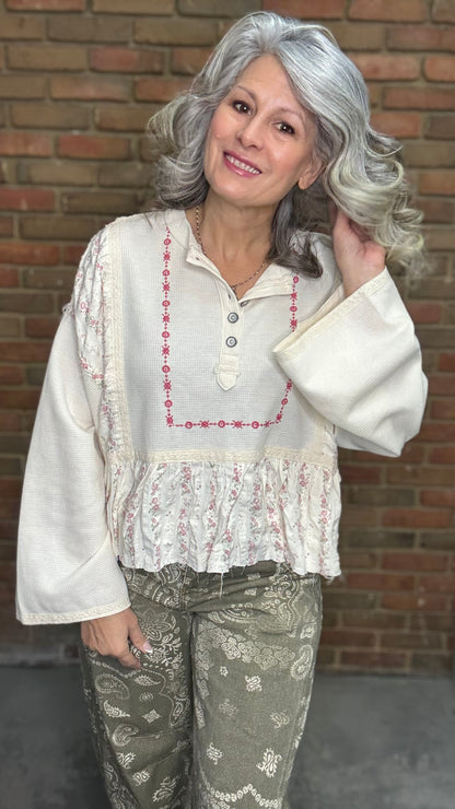 Woman wearing the Natural Flare Sleeve Mix Media Top and Paisley Print Barrel Jean standing against a brick wall.