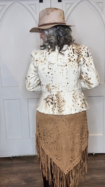 Woman wearing the Cow Print Scallop Edge Jacket with the Camel Faux Suede Fringe Skirt with the Pop&