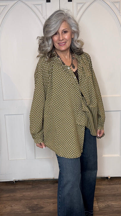 Woman wearing the Sweet Nothings Top-Olive Dot and Judy Blue Palazzo jeans standing against a white paneled wall.