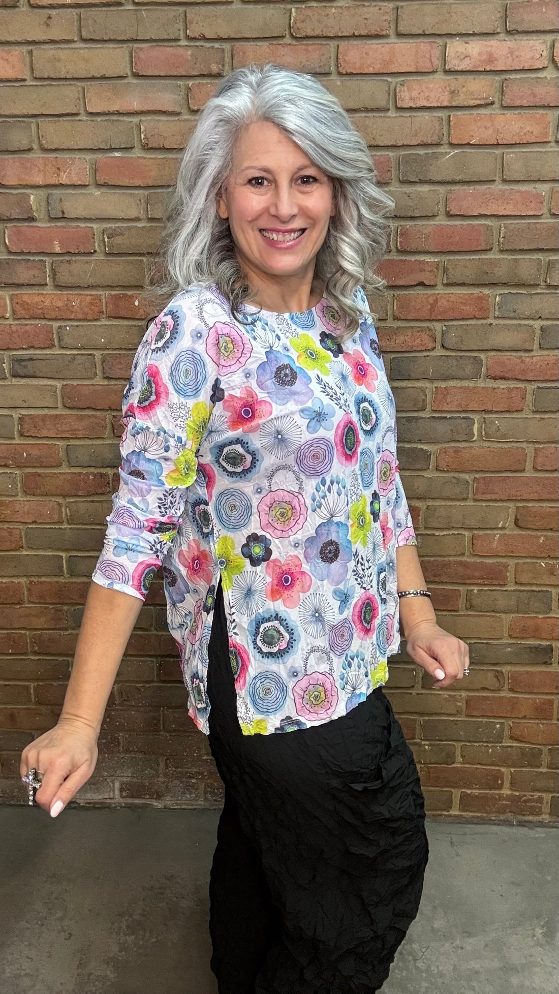 Woman wearing Floral Mesh Topper standing in front of a brick wall.