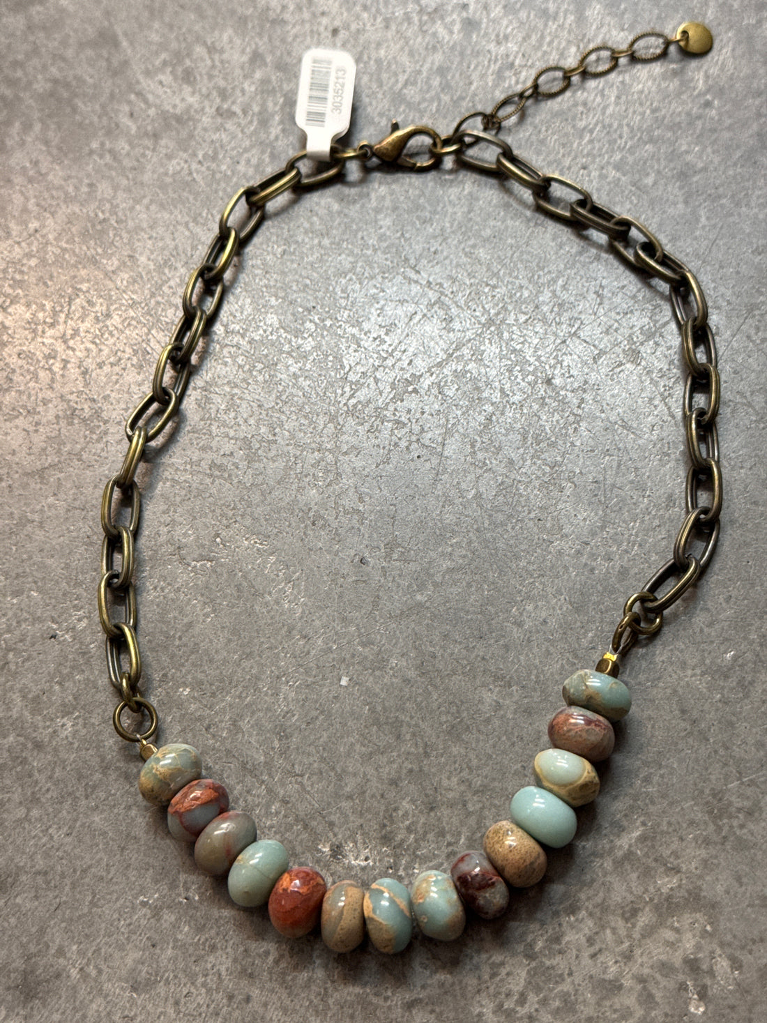 Necklace with beaded chain on a gray surface