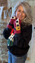 Person wearing colorful gloves with a festive background