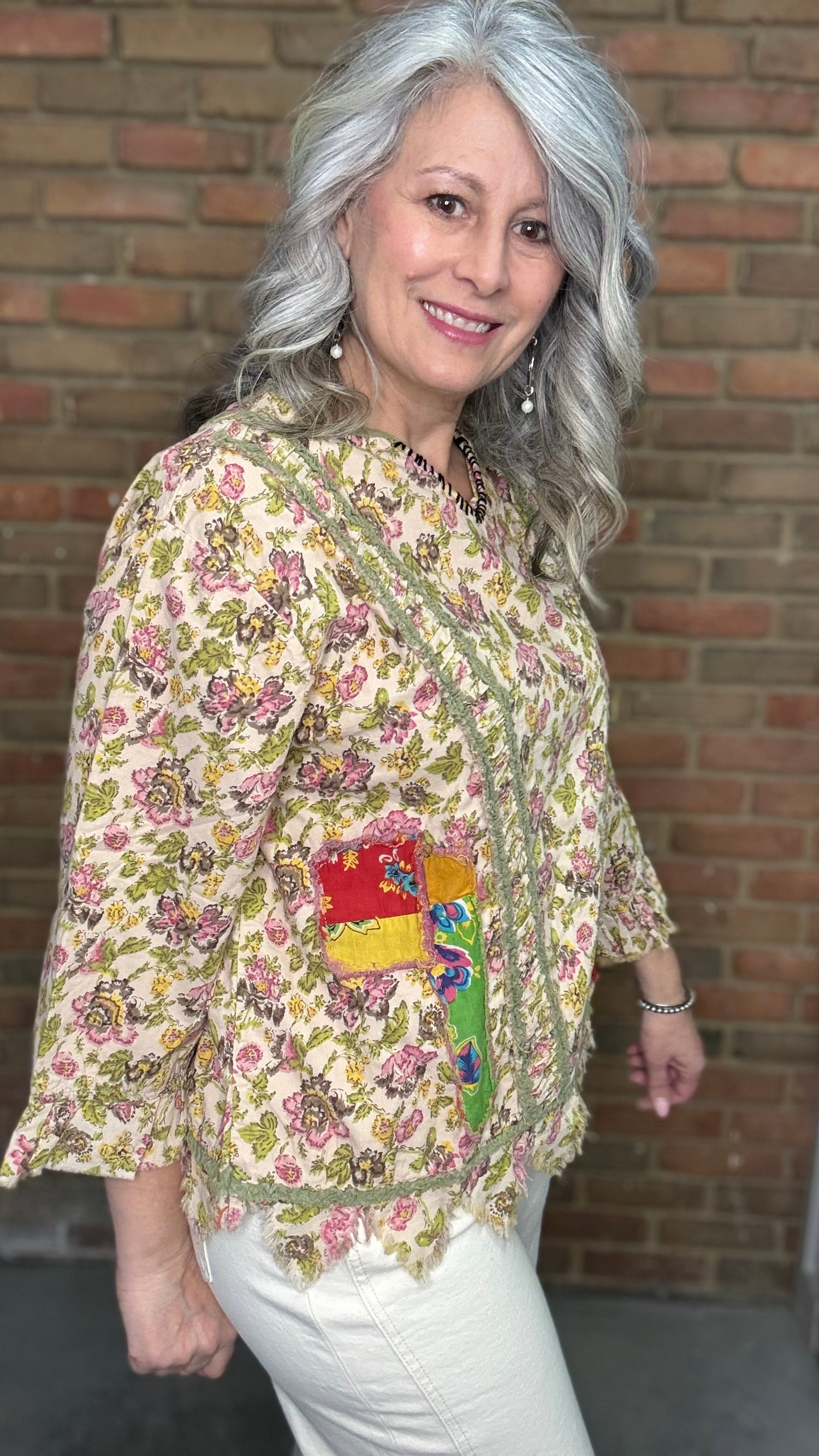 Woman wearing Desert Winds Top  against a brick wall.