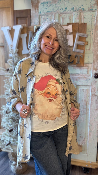 Woman wearing a sweater with a Santa Claus design in a store setting.