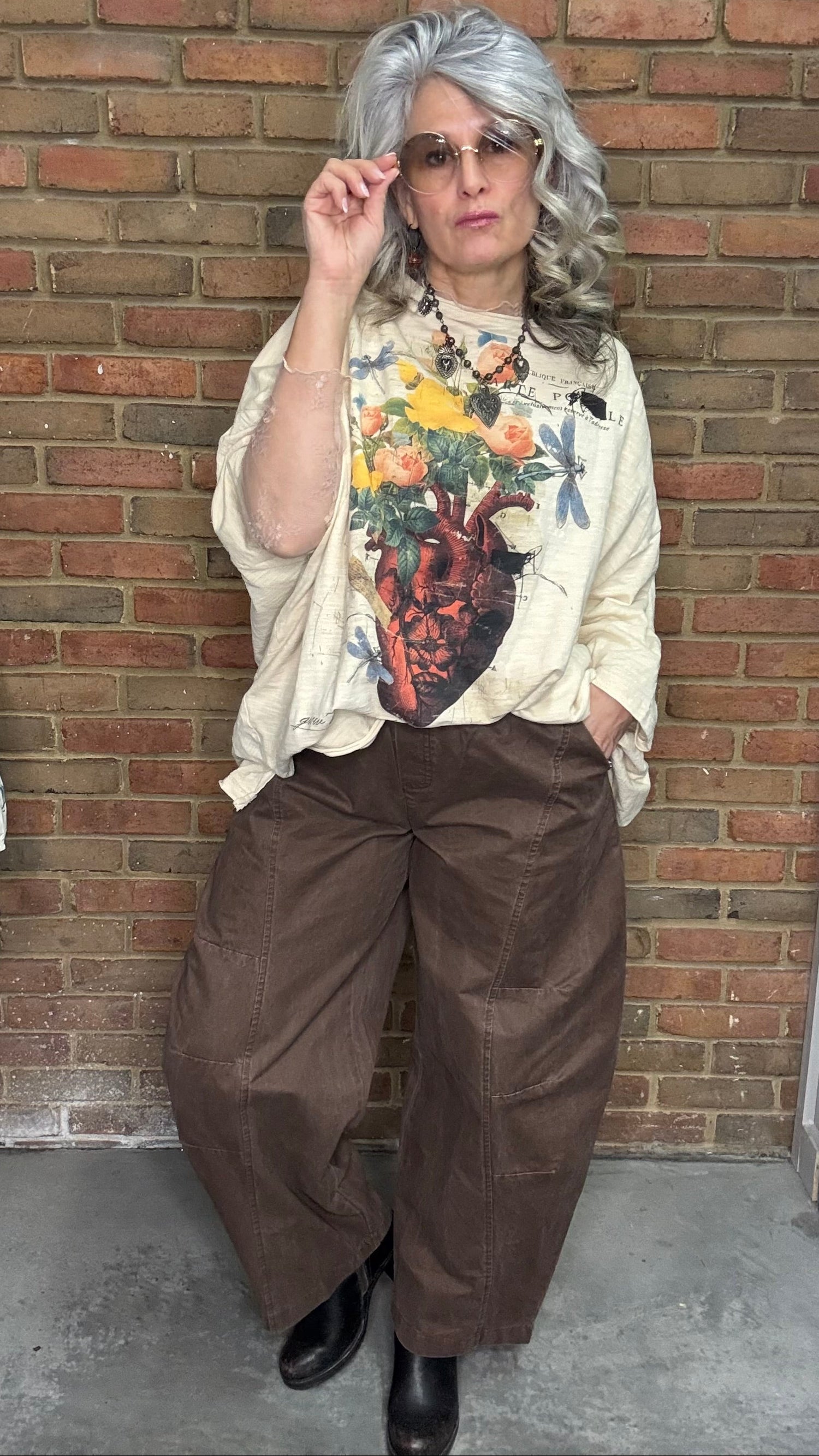 Person wearing Be Free Top - Growth and the Brown Pull On Barrel pants standing against a brick wall.