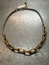 Gold and silver chain necklace on a concrete surface