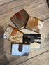 Collection of cowhide leather wallets on a wooden surface